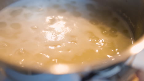 orange water boiling in a pot on a kitchen stove