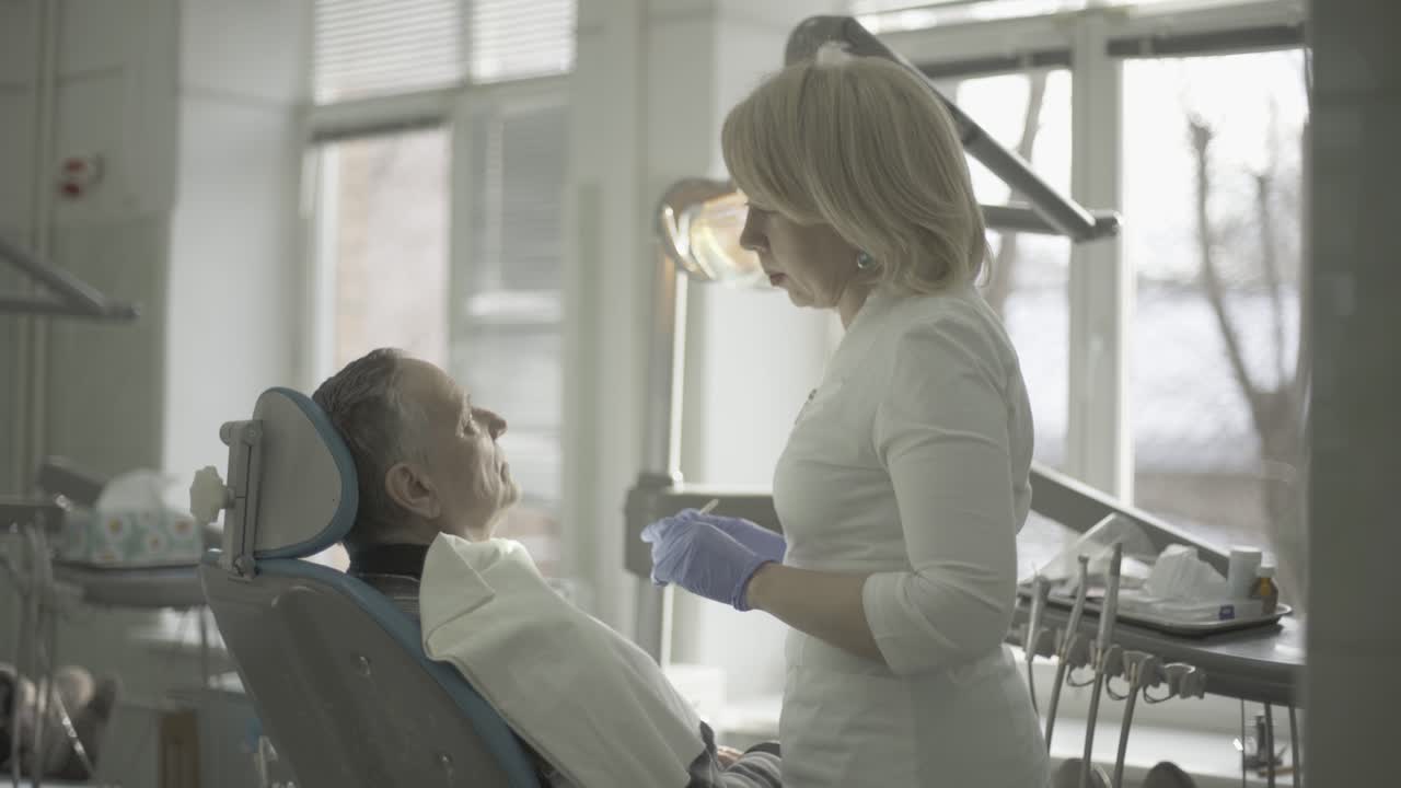 женщина-стоматолог общается с клиентом