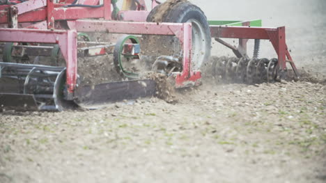 primer plano del campo de cultivo del agricultor usando gradas de disparo en cámara lenta