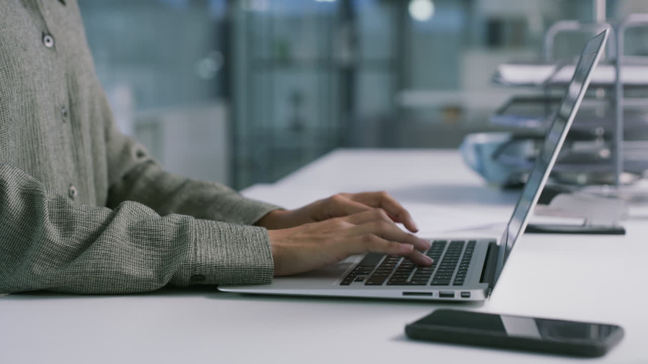 pessoa a digitar num portátil num escritório