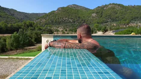 man on the edge of the infinity pool looking at the landscape