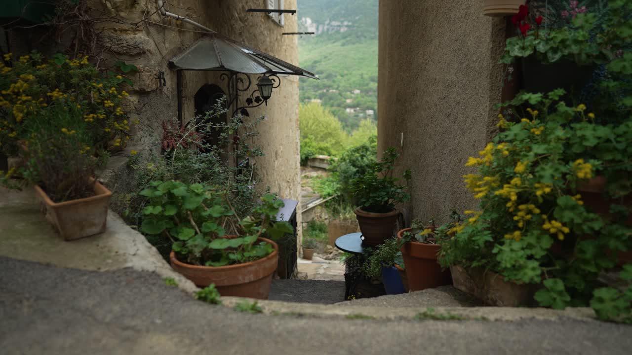 Strada stretta con fiori in un antico borgo in Francia