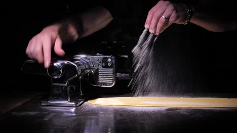 Koch-Gießt-Mehl-Auf-Den-Teig-Und-Verwendet-Die-Maschine,-Um-Traditionelle-Frische-Pasta-Zuzubereiten,-Nahaufnahme