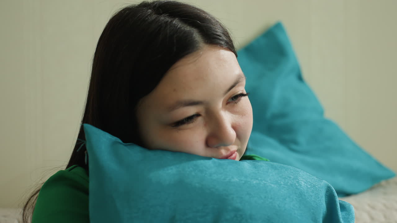 기쁨에 찬 십 대가 서로 껴안고, 십 대가 다채로운 베개를 기쁘게 껴안고, 어린 학생이 생기 넘치는 장식 쿠션을 행복하게 안고, 쾌활한 젊음이 밝은 무늬의 부드러운 쿠션을 들고 행복하게 웃고 있어요.