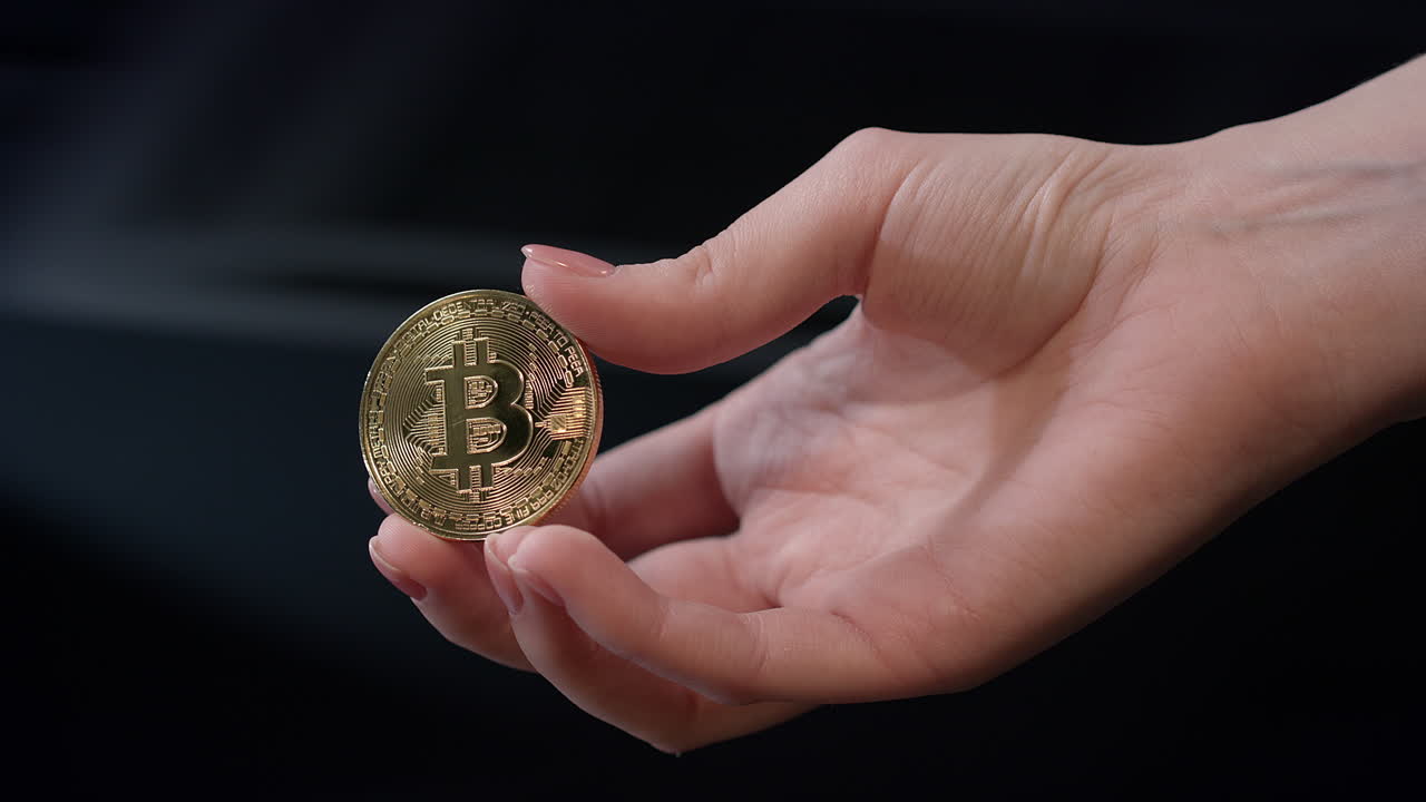 mujer con una moneda de oro de bitcoin en la mano. concepto de negocio de bitcoin. bitcoin en la mano