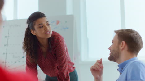 african woman arguing young man office. business people discussing indoors