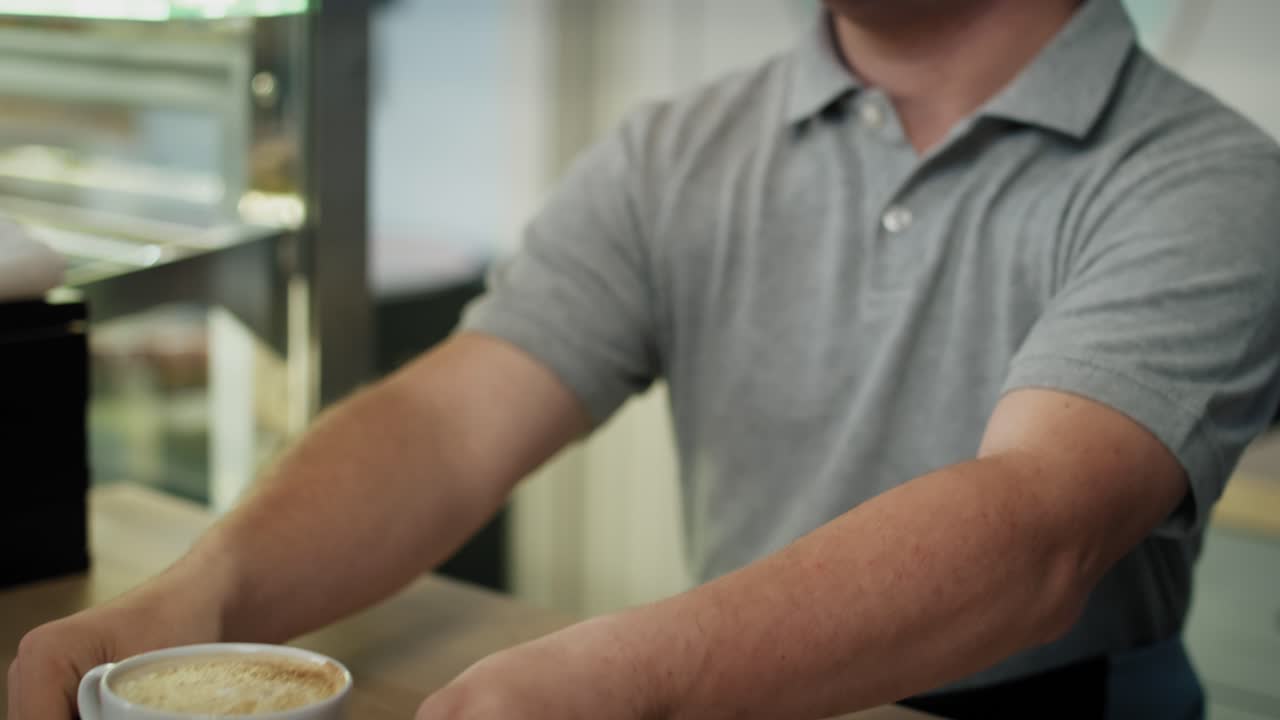 hombre caucásico con síndrome de down caminando y llevando una taza de café.