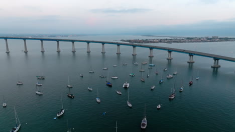 Toma-Cinematográfica-De-Drones-De-Pequeños-Yates-Y-Veleros-Estacionados-Cerca-Del-Puente-Curvo-Coronado-En-San-Diego,-California