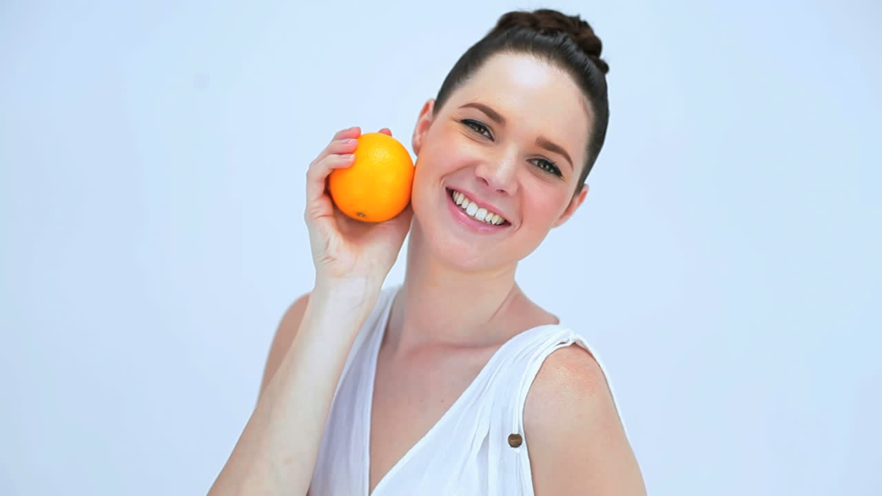 오렌지를 들고 있는 아름다운 여자
