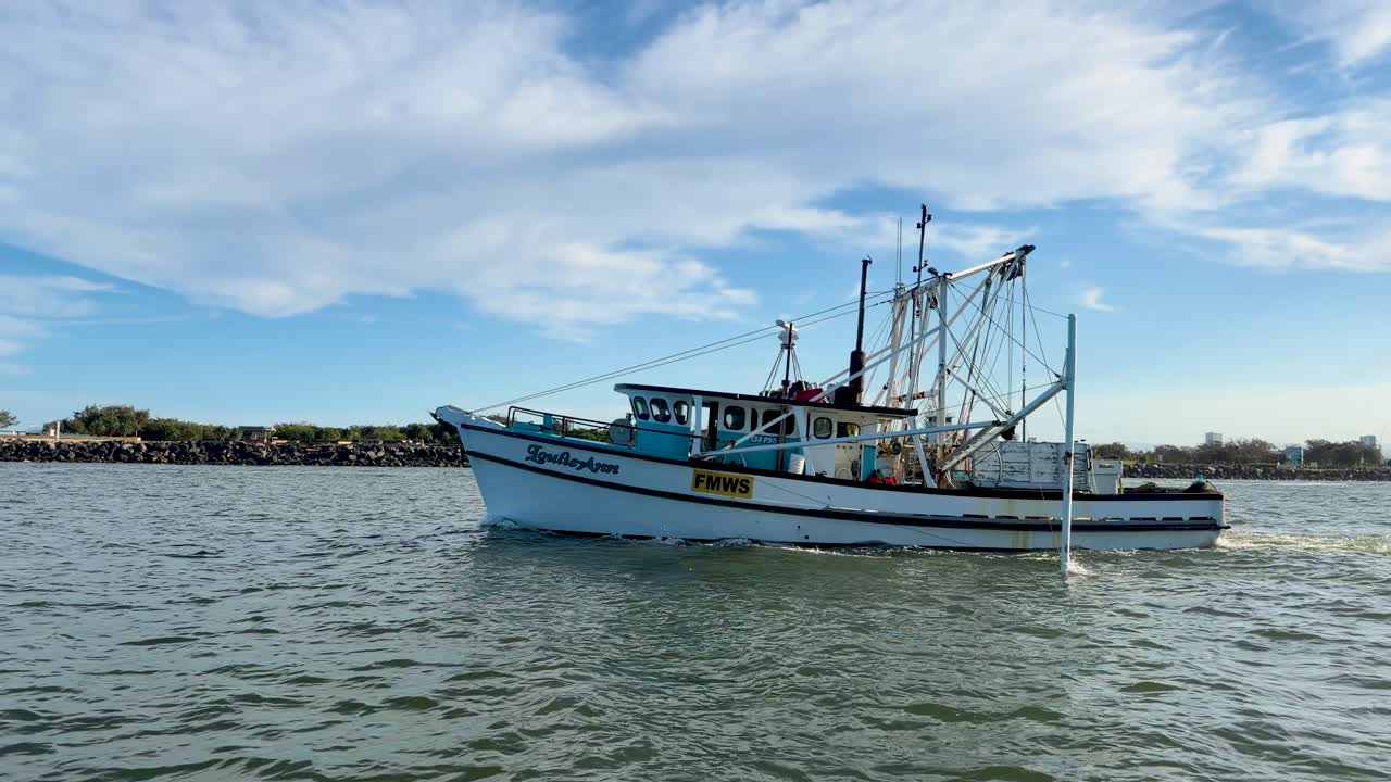 Fishing trawler moves steadily across calm seawater under bright daylight, wide shot, Gold Coast