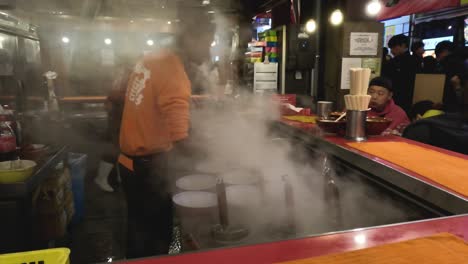 chef prepares noodles with theatrical smoke effect