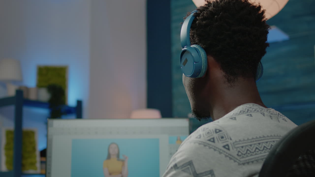 Photographer retouching pictures on computer and wearing headphones