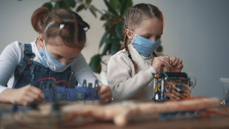 Bambine Con Mascherina Che Costruiscono Robot 1