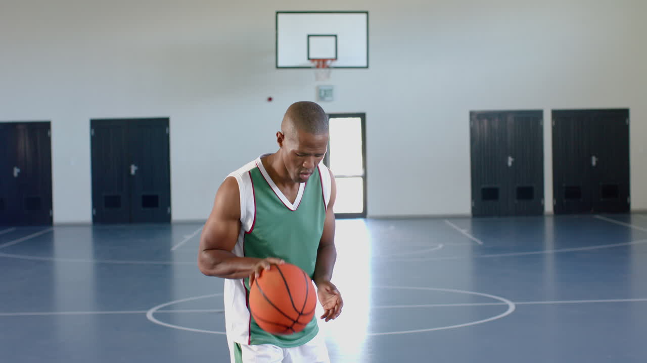 hombre afroamericano jugando al baloncesto en el interior, con espacio de copia
