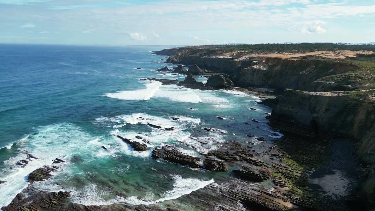 Riprese aeree con drone di Praia do Cavaleiro, Portogallo: aspre scogliere atlantiche, onde oceaniche e un paesaggio costiero drammatico sotto luce naturale. Ideale per progetti di viaggio e natura.