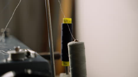 Close-up-of-cotton-thread-spool-bobbin-on-sewing-machine