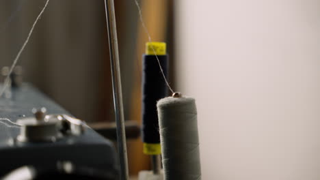cerca de la bobina de bobina de hilo de algodón en la máquina de coser