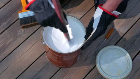 stirring in a bucket of white decking oil