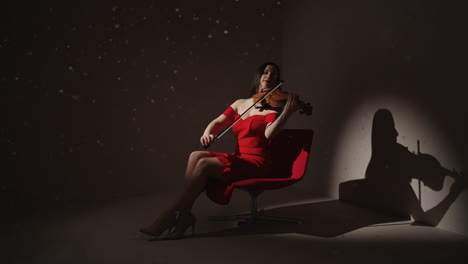 mujer tocando el violín en vestido rojo