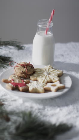 vertical video of bottle of milk, cookies with copy space on snow background