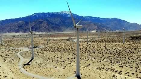 molinos de viento, energía de turbinas eólicas, verde, renovable, granja generadora de energía, dron aéreo 4k de derecha a izquierda sobrevuelo lateral, con mt nevado