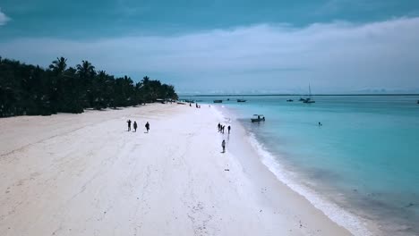 Gran-Vuelo-Aéreo-Volar-Hacia-Atrás-Drone-Disparado-Sobre-Playa-De-Arena-Blanca-Agua-Turquesa-Y-Gente-Paraíso-Sueño-Playa-Zanzíbar,-áfrica-Tanzania-2019-Cinemática-Naturaleza-Salvaje-1080,-60p-Por-Philipp-Marnitz