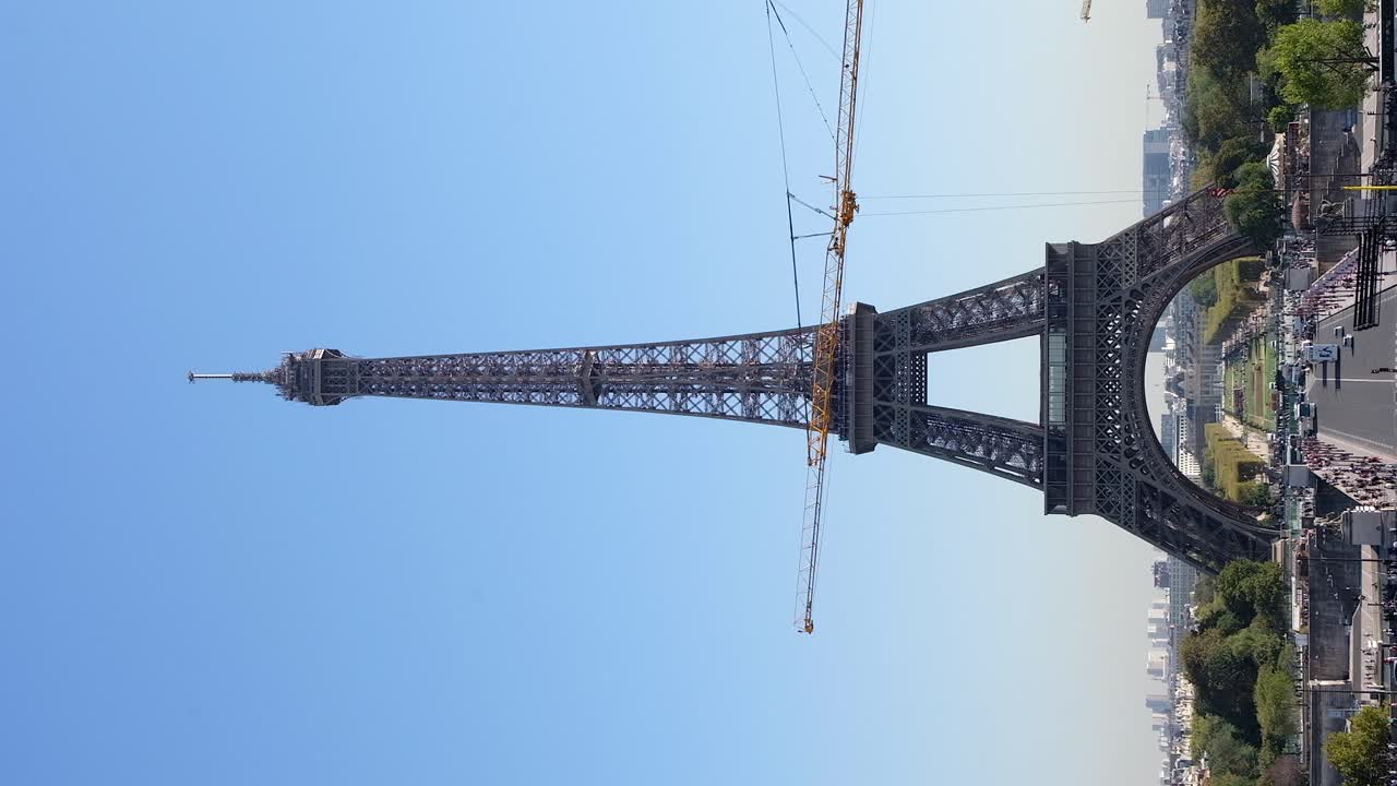 Cars moving under the Eiffel Tower in Paris, France. Vertical