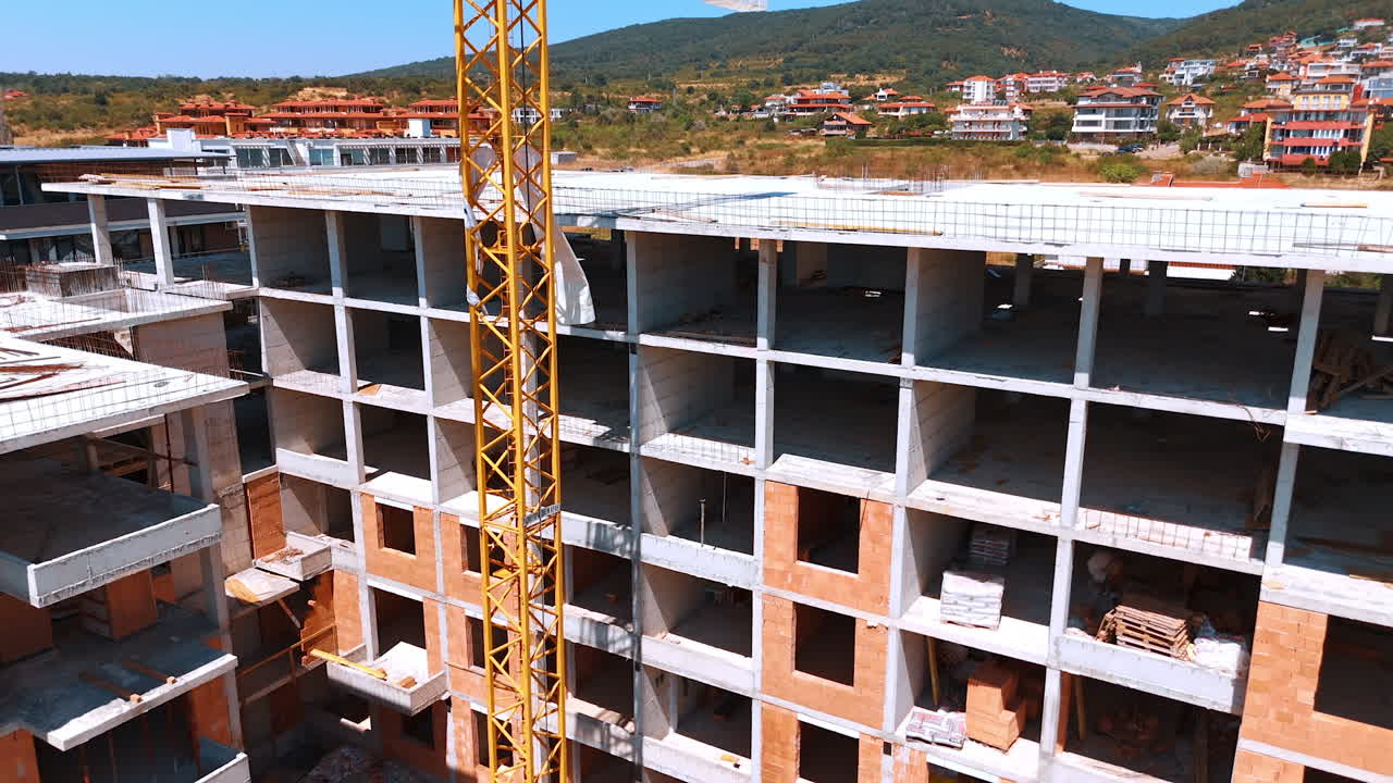 Varna, Bulgaria, 11 July 2025: Multi-story building under way. Workers are actively constructing a multi-story building with a crane visible under a clear blue sky