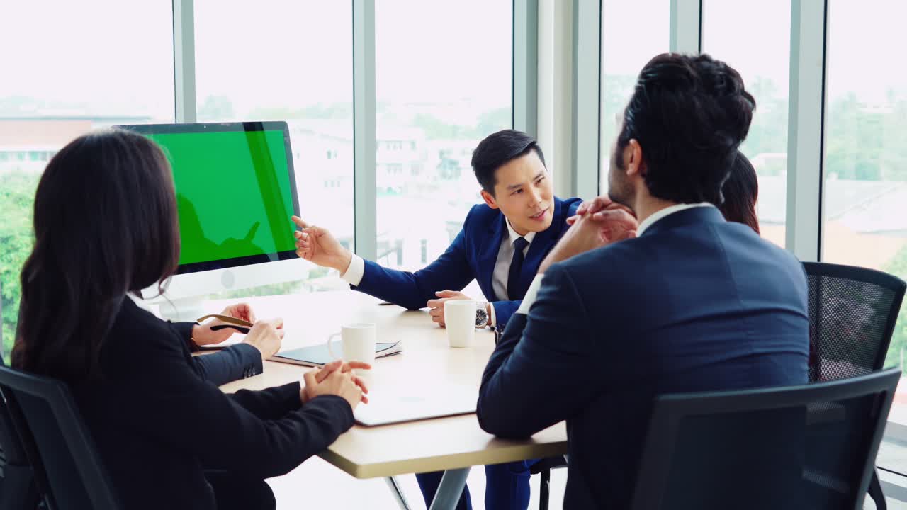 녹색 스크린을 가진 회의실에 있는 비즈니스 사람들
