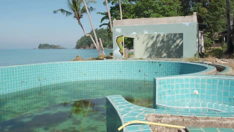 Tiro-Inclinado-Hacia-Arriba-De-Una-Piscina-Vacía-En-Un-Balneario-Abandonado-En-Tailandia