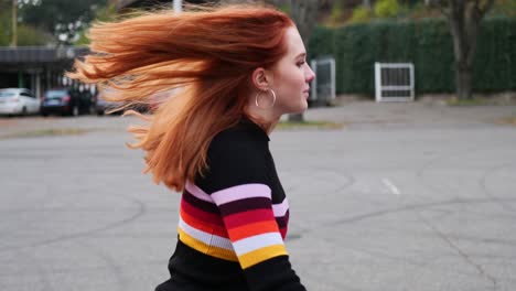 slow motion of pretty young girl with red hair riding roller skates in outdoors