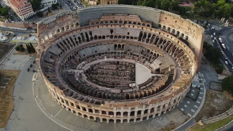 the colosseum in rome, seen from above, bathed in warm sunset hues with clouds