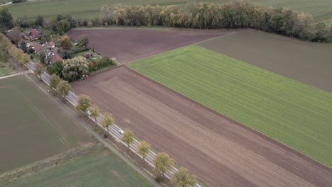 Drone-aerial-tracking-shot-of-a-german-farmer-harvesting-his-field-in-late-autumn