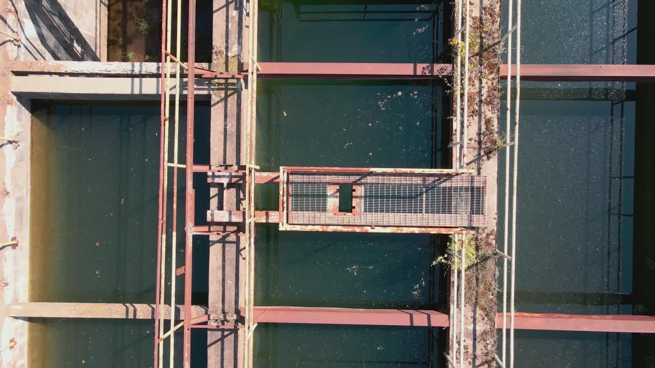 paso elevado a vista de pájaro de una estación de agua abandonada ahora cubierta de vegetación y llena de agua de lluvia
