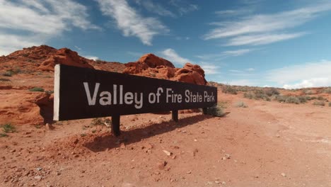 The-Valley-of-Fire-Welcome-Sign-Along-the-Highway-in-Nevada,-USA-with-Slow-Motion-Panning-Shot