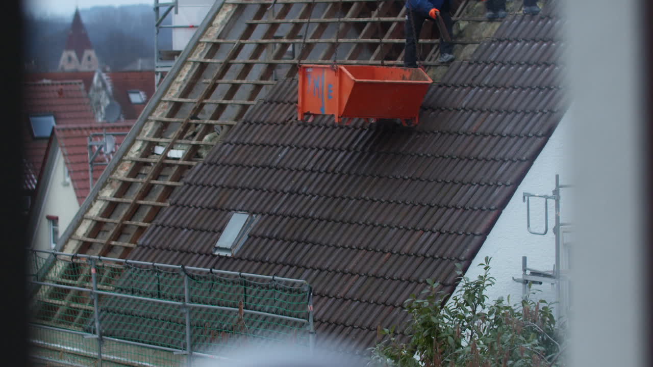 Slow motion shot of a roof getting removed tile by tile