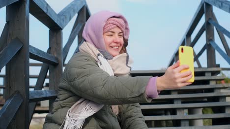 woman taking selfie outdoors in winter