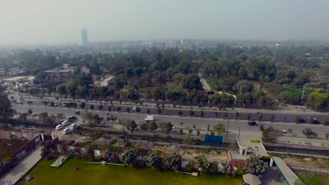 Bombay,-India,-tilting-up-camera-city-view,-a-big-highways-with-traffic,-foggy-weather,-small-tree-forest-in-the-city