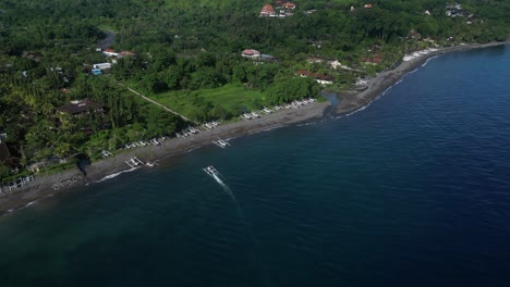 the beautiful sunny coastline of amed, bali, indonesia with a boat coming in to dock