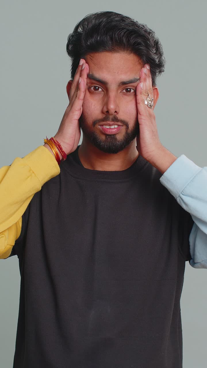 Indian man rubbing temples to cure headache problem suffering from tension and migaine stress pain