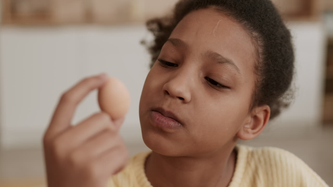 Girl Looking at Egg Smiling