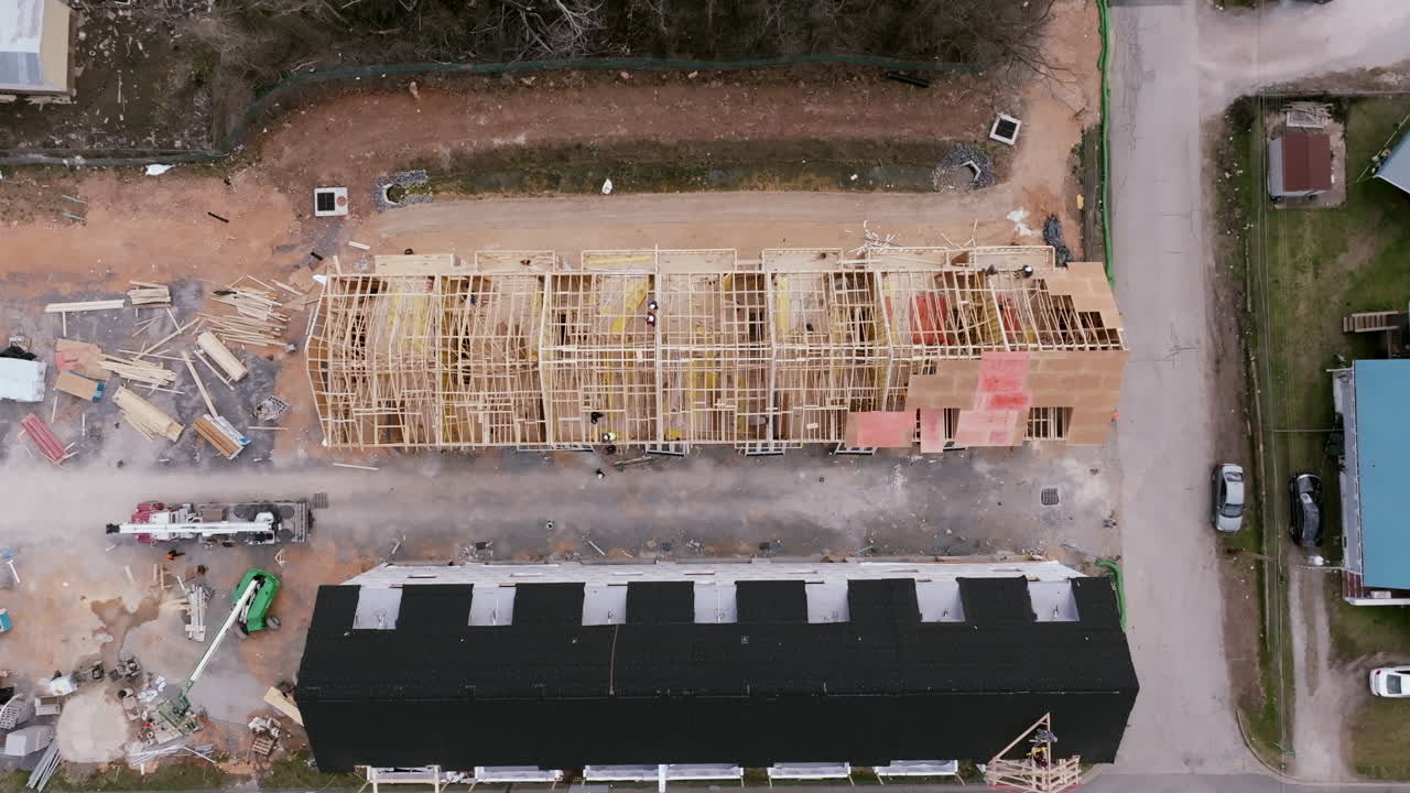 Top down aerial footage of construction workers on the unfinished roofs of townhomes in Chattanooga, TN.