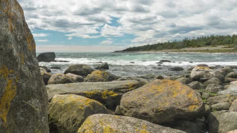 Time-lapse:-waves-repeatedly-crashing-against-rocky-coast,-tidal-motion