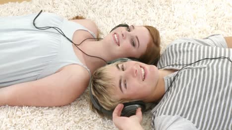 una pareja de adolescentes escuchando música mientras se relajan.