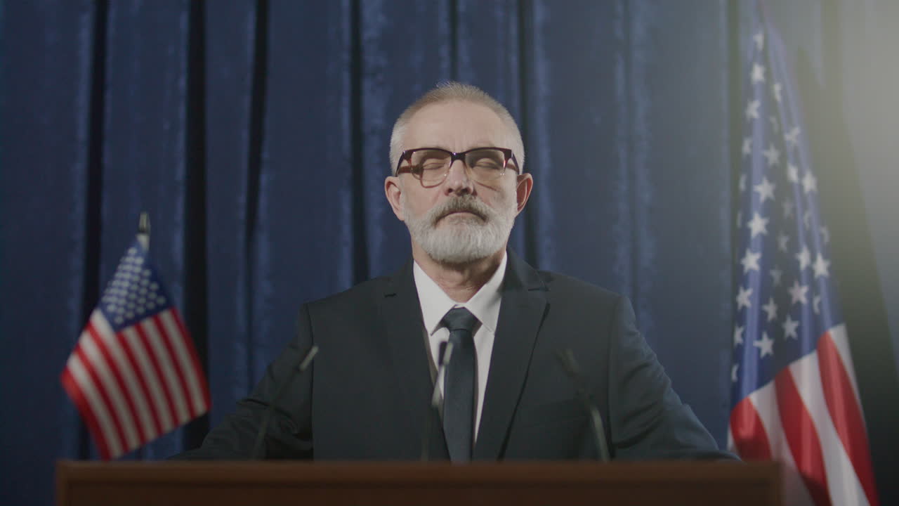 Portrait of Senior Politician at Podium with US Flags during Press Conference