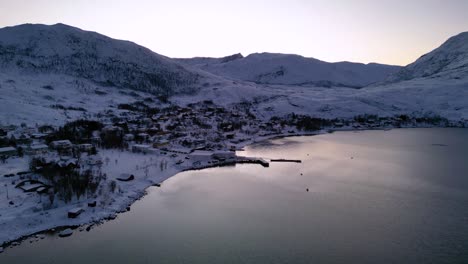 cinematic view of norwegian fjords and ersfjordvegen village with snowy mountains and blue sea