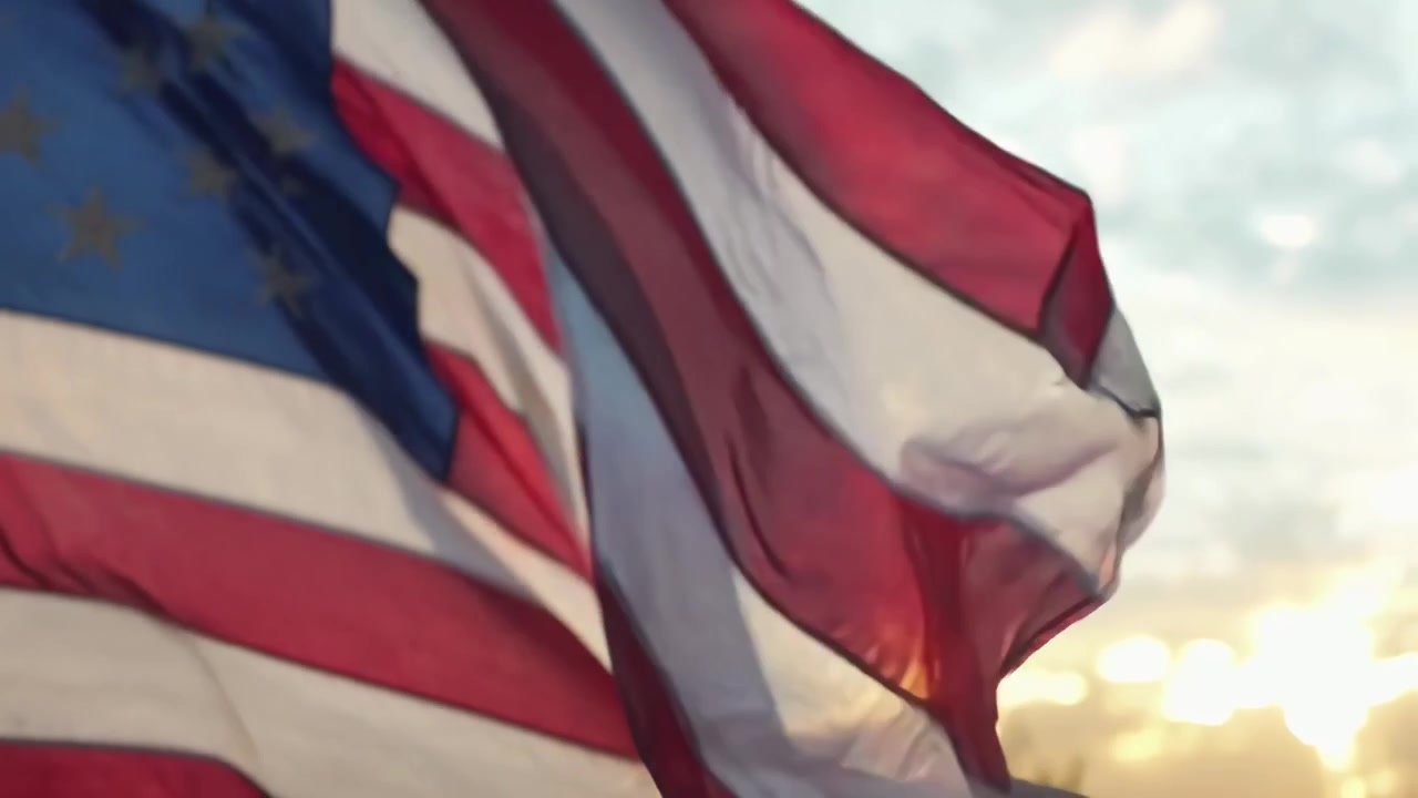 De Amerikaanse vlag zwaait in de wind bij zonsondergang