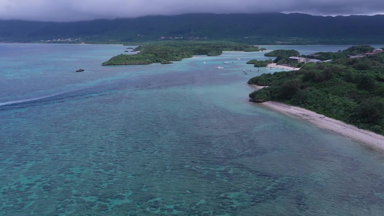 Riprese aeree orizzontali che si spostano a sinistra e poi panoramicano a destra sopra la laguna turchese, la barriera corallina e le piccole isole di Kabira Beach e Bay vicino a Club Med e Tabaga Beach, Giappone