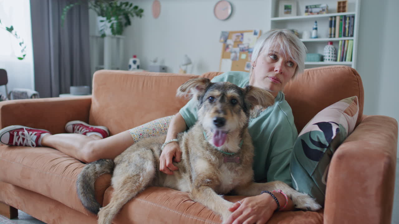 Young Woman Relaxing with Dog on Couch in Cozy Living Room