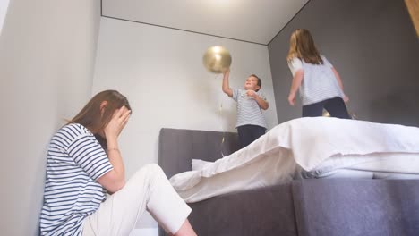 Family having fun with balloons in the bedroom